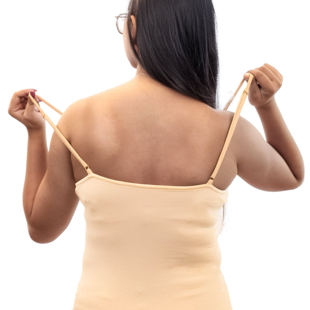 Woman wearing a beige camisole against a white background