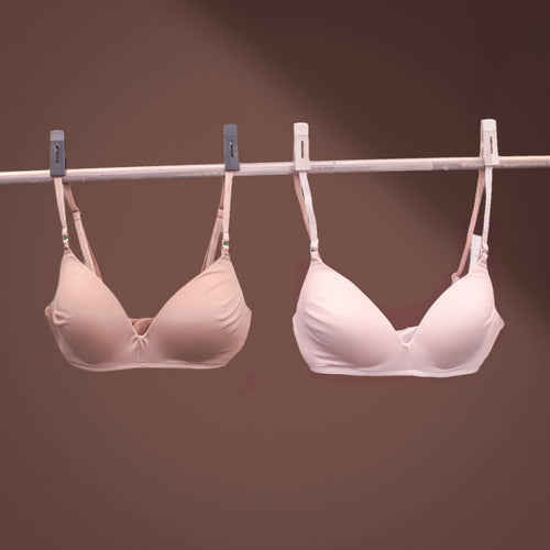 Two Charmella Invisible Bras hanging on a clothesline against a brown background