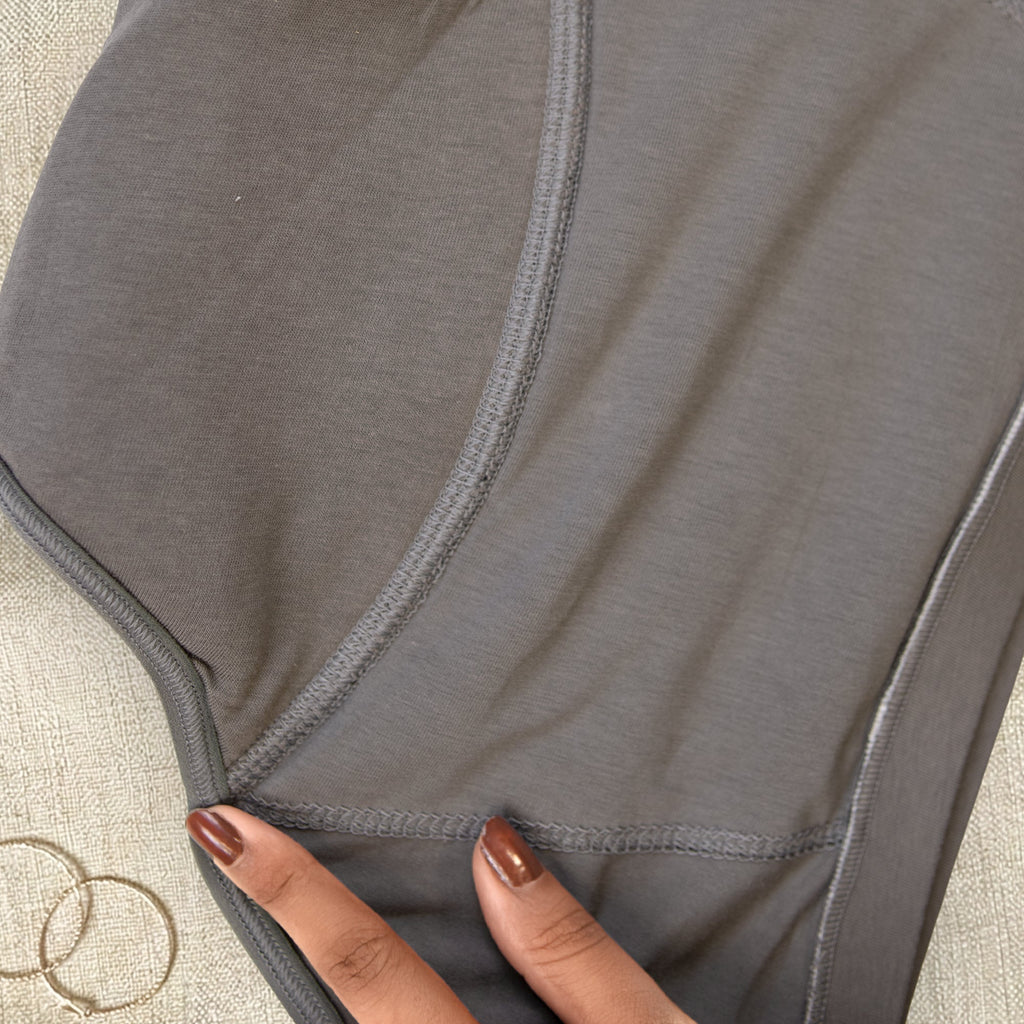 Charmella Period Panty with a hand touching the fabric on a textured surface