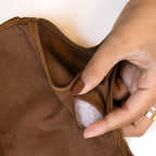Close-up of a hand inspecting the inside of a Charmella Slip-On Bra.