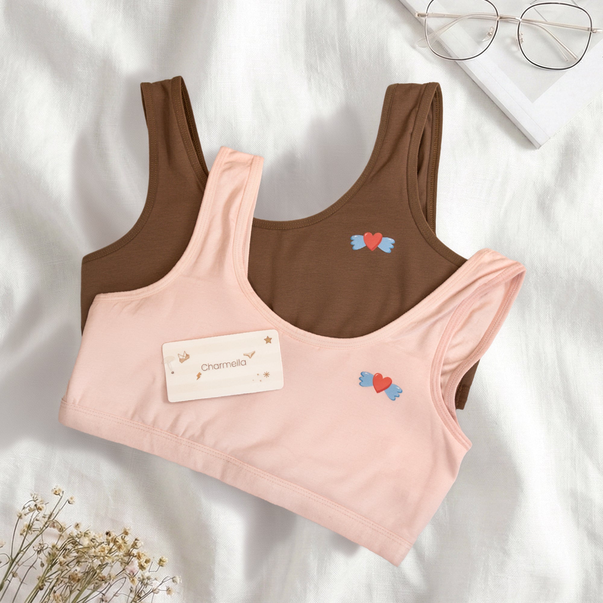 Two Charmella Slip-On Bras, one pink and one brown, with heart designs.