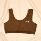 Charmella Slip-On Bra with colorful heart design on a beige background