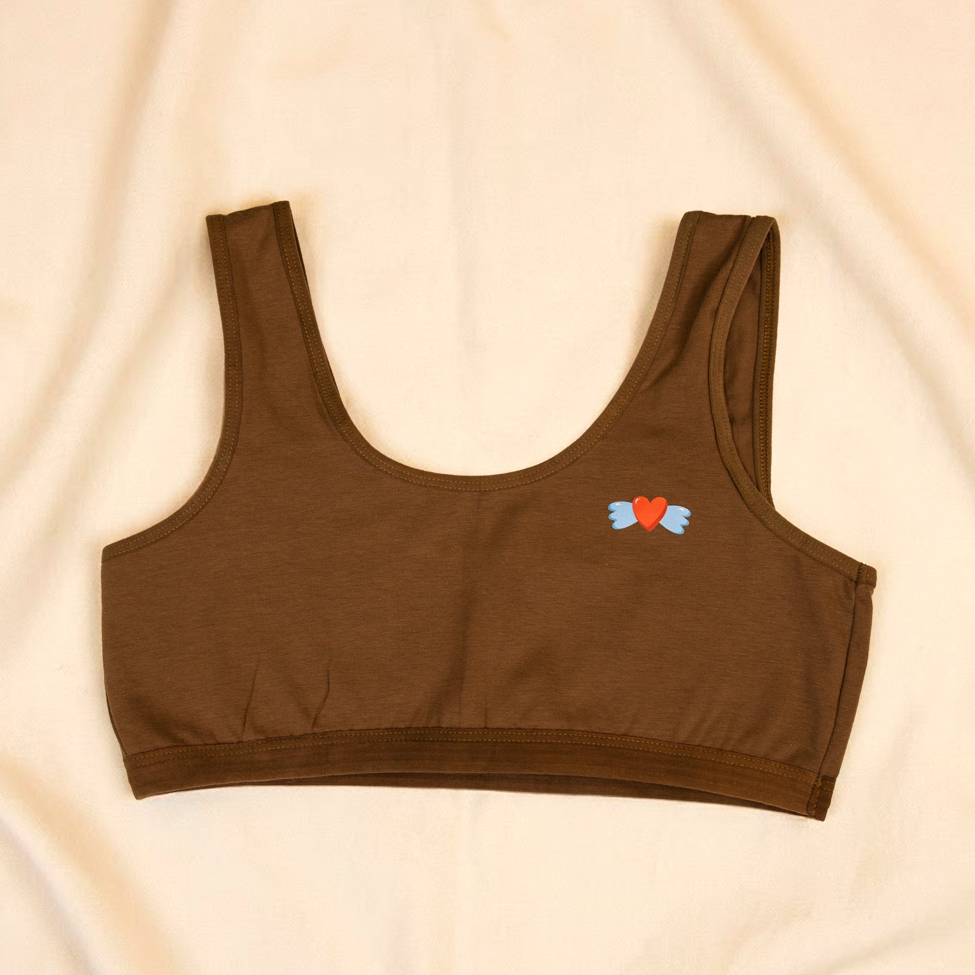 Charmella Slip-On Bra with colorful heart design on a beige background