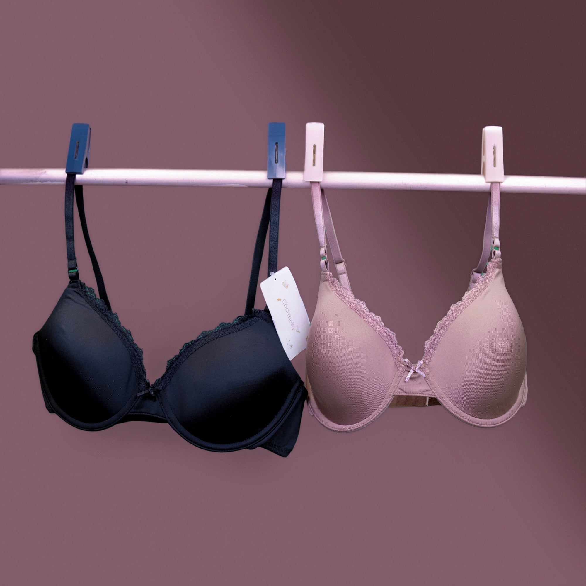 Charmella T-Shirt Bras hanging on a rack against a purple background