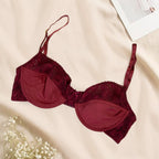 Red bra with lace details on a beige surface
