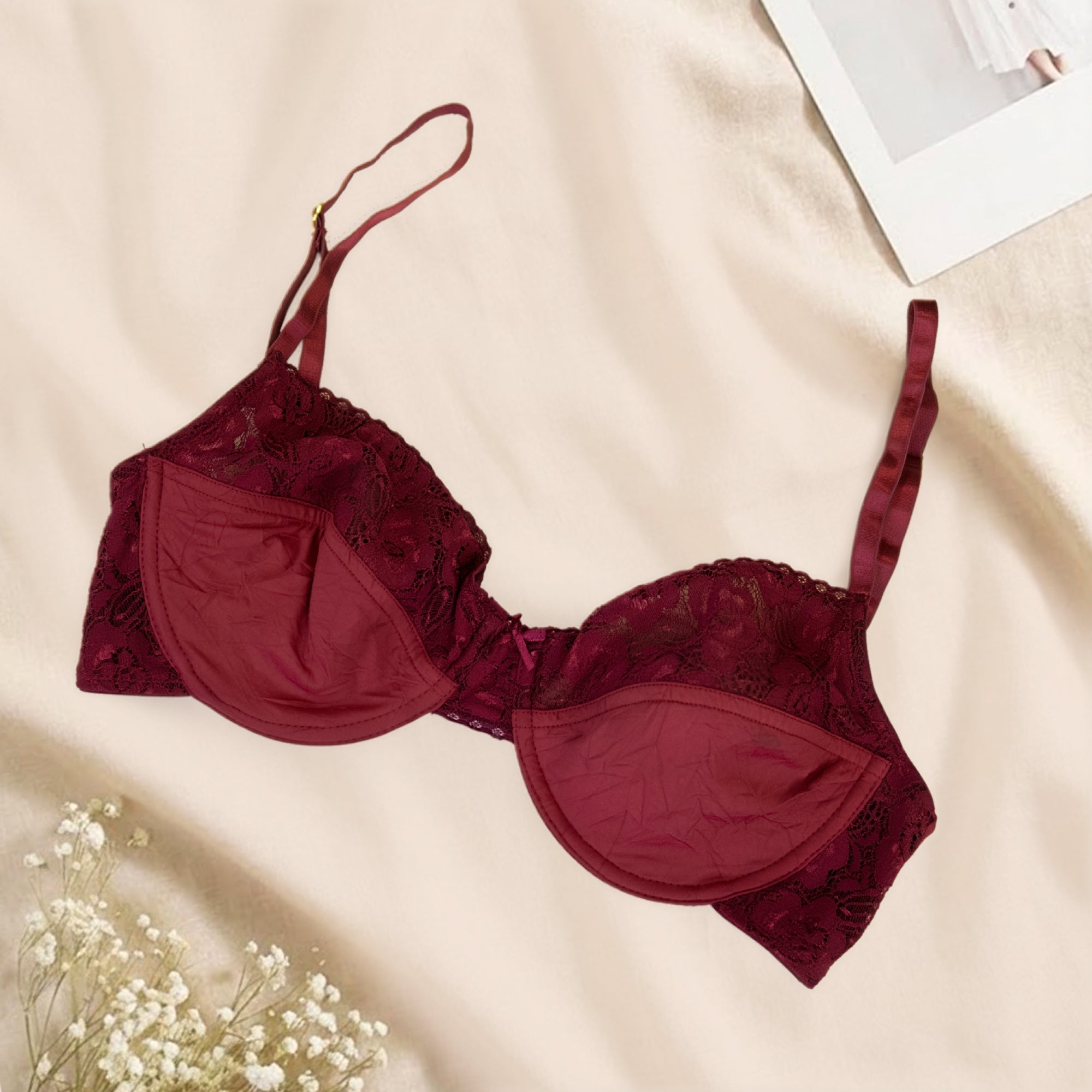 Red bra with lace details on a beige surface