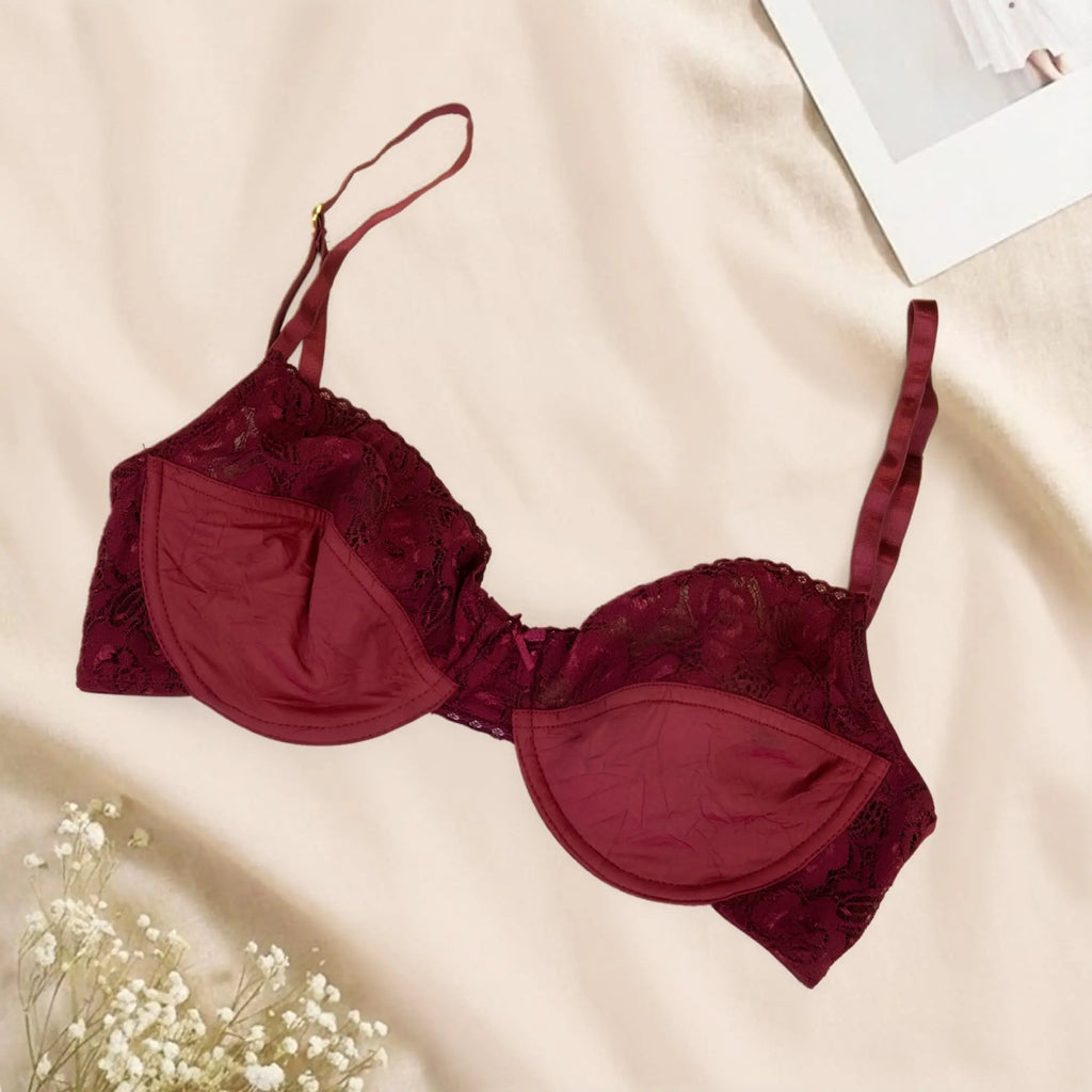 Red bra with lace details on a beige surface