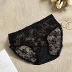 Black lace underwear on a textured surface.