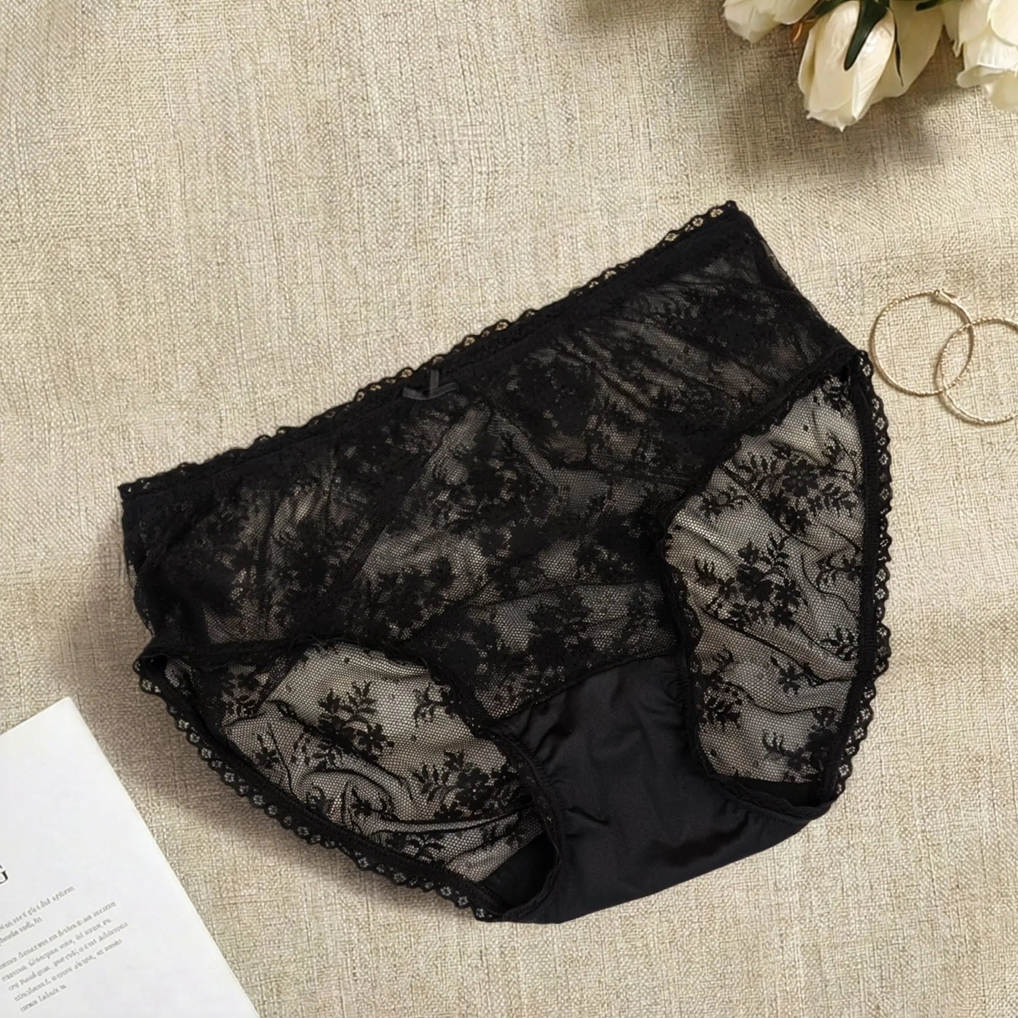 Black lace underwear on a textured surface.