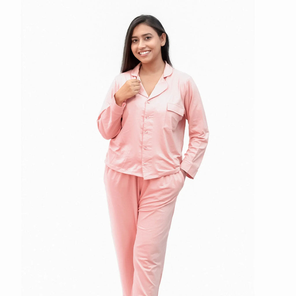 Woman wearing a pink satin pj set on a white background
