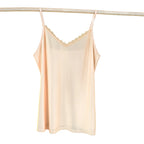 Light pink satin camisole with lace trim on a white background
