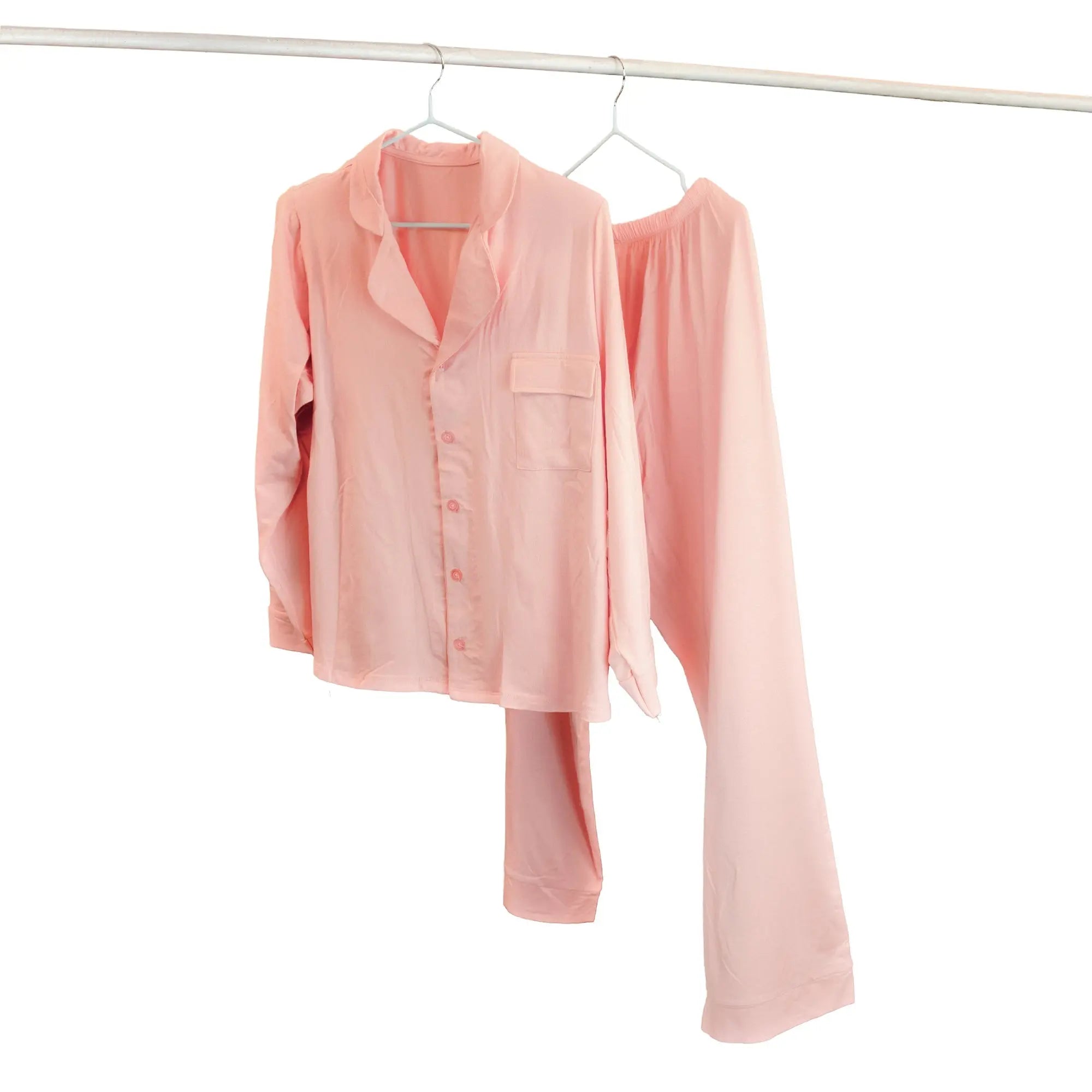 Pink PJ set & pajama set hanging on a white background